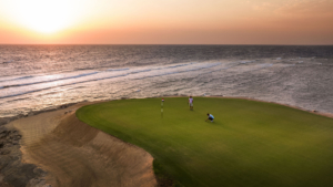 Zwei Golfer auf dem Green direkt am Meer bei Sonnenuntergang in Somabay